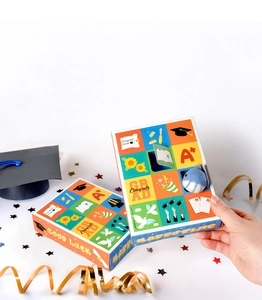 Detail of graduation gift box set featuring Congrats Grad motifs and plush whale charm