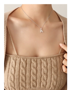 Vue détaillée du pendentif lettre H sur une chaîne de collier en titane plaqué or 18k