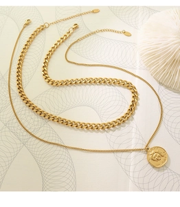 Detailed macro of 18K gold-plated double-layer necklace with lion coin and Cuban link