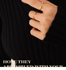 Detailed view of polished 18K gold plated stainless steel teardrop open ring on model