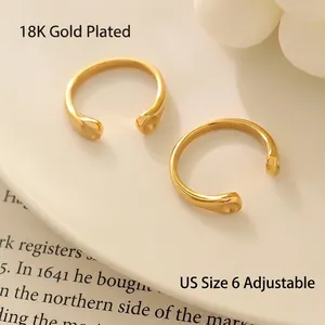 Polished 18K gold plated stainless steel open rings with teardrop design on white tray