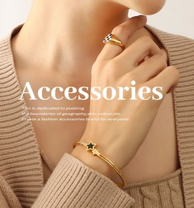 Detail of gold star bracelet and checkerboard ring on model with knit sweater