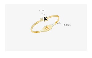 Detail of gold star hinge bracelet showing 1cm black star charm and 0.25cm band width