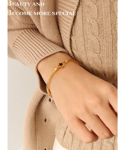 Close-up of golden stainless steel star bracelet with black inlay and small crystals