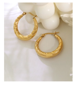 Dettaglio di orecchini a cerchio a U placcati in oro 18K con motivi geometrici in bambù