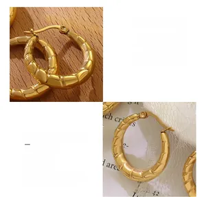Dettaglio macro degli orecchini a forma di U in acciaio chirurgico dorato con finitura lucida
