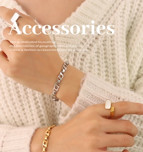 Détail de bracelets à fleurs ajourées et bague dorée ajustable au poignet du modèle