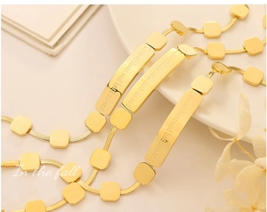 Macro detail of gold plated bracelet with engraved inspirational text on square metal bars