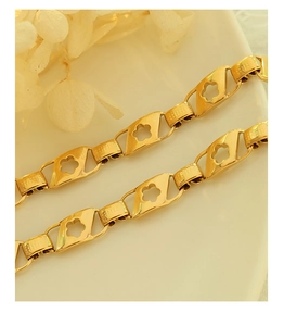 Détail macro du bracelet à maillons fleurs dorées avec boucles texturées sur céramique