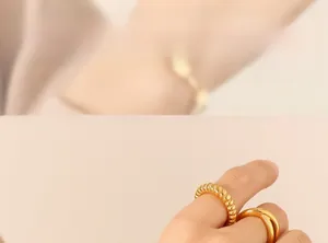 Close-up of gold croissant ring and criss-cross band with polished 18K gold finish