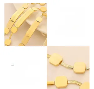 Macro view of 18K gold plated snake chain bracelet with engraved geometric charms