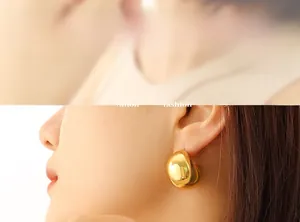 Close-up of model wearing chunky golden hollow C-shape teardrop earrings in 18K gold finish