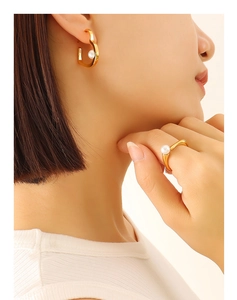 Detail of 18K gold-plated earrings and ring set with pearls on a female model