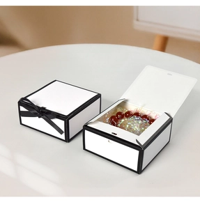 Dettaglio di eleganti scatole regalo bianche e nere con nastro e carta di riempimento