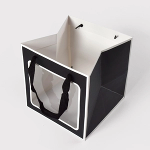 Minimalist black gift bag with transparent window and black woven handles for events