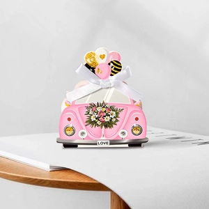 Roze geschenkdoos in de vorm van een auto met hartballonkaart en wit lint voor bruiloften