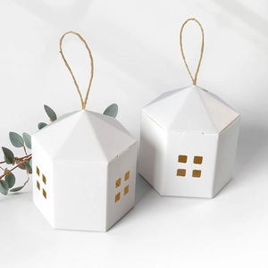 White hexagonal house gift box with hollow windows and twine handle on gray background
