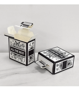 Detail of minimalist perfume bottle shaped gift box with black and white floral prints