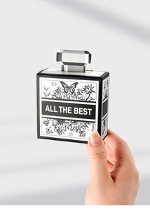 Macro detail of a perfume-shaped black and white flower gift box with a silver handle