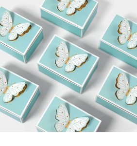Detail of Tiffany blue wedding favors boxes with 3D white and gold glitter butterflies