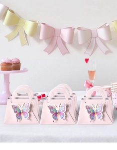Macro view of pink butterfly gift boxes with 3D wings and integrated round handle for parties