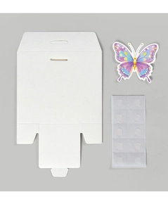 Flat lay of DIY wedding favor box components including cardstock, butterfly and glue dots
