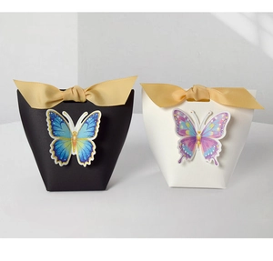Detail of 3D butterfly embossed gift boxes with elegant golden ribbon bows on white card