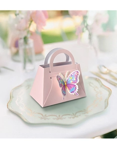 Detailed view of pink handbag-shaped gift box with holographic butterfly on a white tray