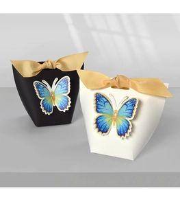 Detail of elegant black and white wedding gift boxes with gold ribbons and blue butterflies