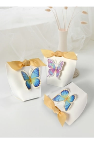 Close-up of elegant white gift bag with yellow ribbon and 3D decorative butterfly