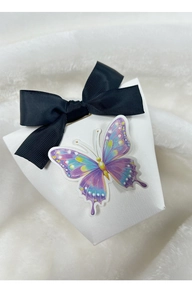 Detail of white cross-textured gift box with black ribbon bow and purple 3D butterfly