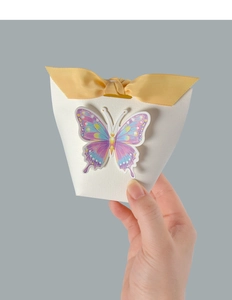 Detail of white textured gift box featuring a bright yellow bow and colorful 3D butterfly