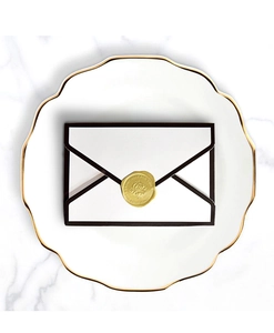 Minimalist white envelope gift box with black edge and golden wax seal on marble