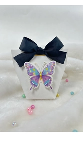 Detail of white embossed gift box with a colorful 3D butterfly and black ribbon bow