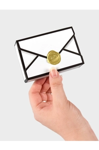 Detail of white envelope gift box with black 2D lines and gold wax seal stamp