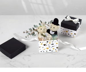 Detail of plush wedding teddy bears in square gift boxes with heart patterns