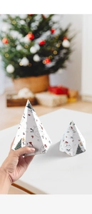 Détails des motifs mouton et sapin de Noël sur des boîtes cadeaux hexagonales en carton