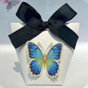 Minimalist white textured wedding candy box with a large black bow and blue butterfly