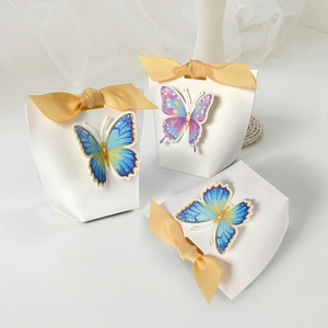 Three elegant white butterfly candy boxes with satin ribbons for wedding party favors
