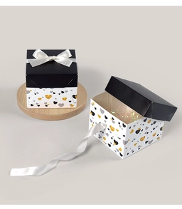Detail of luxury square gift boxes with heart patterns and elegant white satin bows