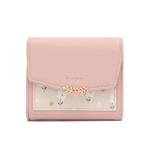 Détail du portefeuille en similicuir rose avec boucle feuille dorée et imprimé fleuri
