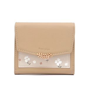 Détail du portefeuille en cuir avec boucle feuille dorée et motifs floraux