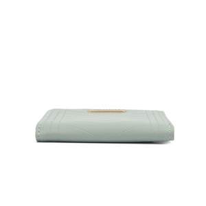 Detail of mint green slim wallet showing the V-shaped stitching and gold metal logo plate