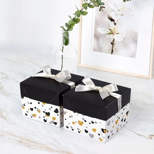 Square gift boxes with cream ribbon bows and heart pattern on a high-end minimalist design