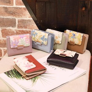 Close-up of floral print PU leather wallets with metallic snap buttons and zipper pockets