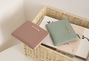 Detail of V-quilted texture and gold metal logo on elegant pastel ladies' wallets