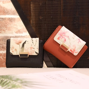 Detail of floral printed small wallets in black and tan PU leather with gold clasp