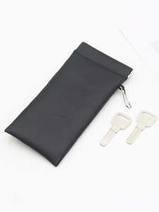 Close-up of black leather pouch with spring clip closure and side metal keychain hook
