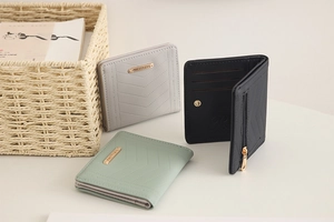 Detailed view of the V-quilted texture and metal logo on these women's compact folding wallets
