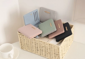 Detail of colorful V-quilted bifold wallets with multiple card slots and metal logo
